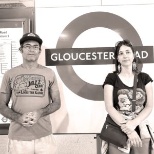 Mr. Strontium and Meg Cratty standing in front of a sign reading "Gloucester Road"