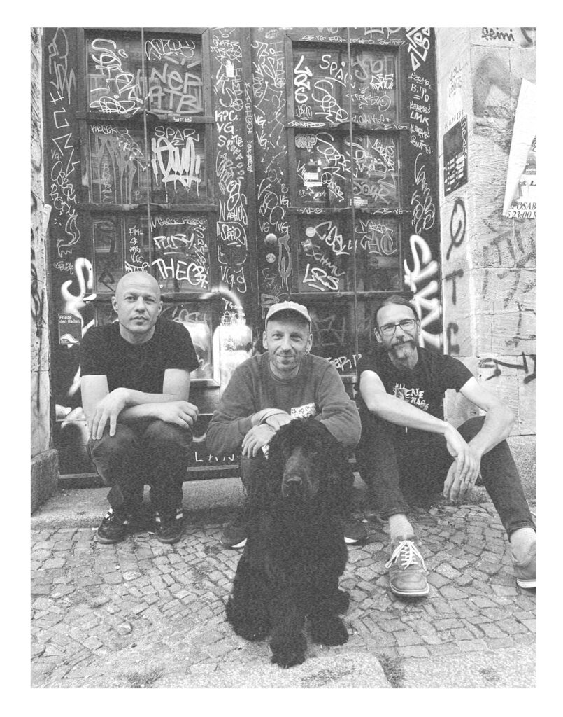 Band picture of Abrichten and a dog sitting in front of a door